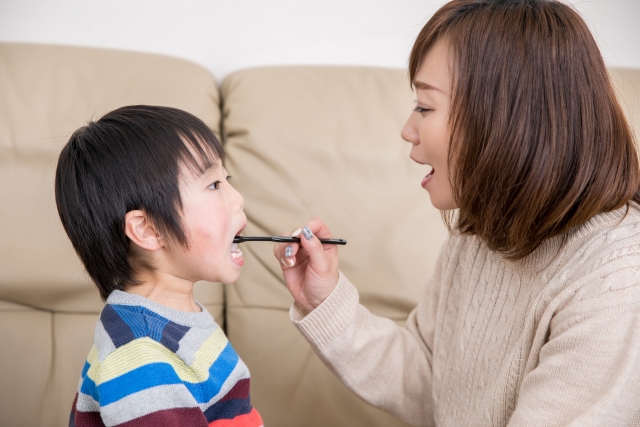 子どもの口の中を確認する保護者
